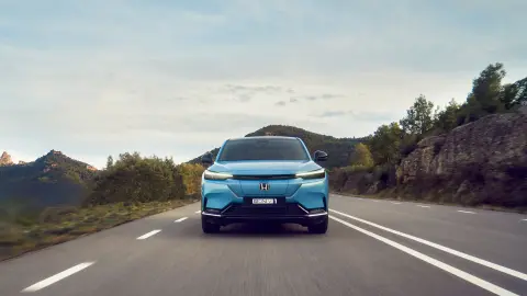 Fontal del Honda e:Ny1 conduciendo por una carretera en un lugar montañoso.