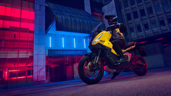 Vista frontal de tres cuartos de la edición especial de la X-ADV parada con piloto