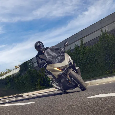 Modelo sobre una motocicleta Forza 750 circulando por una calle.